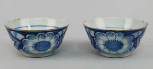 A pair of tin glazed earthenware bowls, 18th/19th century, decorated with large flowerheads between diamond form chevrons, 16cm diameter (2)