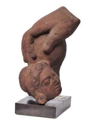 A red sandstone fragment of a hand and female head,  Madhya Pradesh, India, 10th century, the large hand resting on a spherical object, the female head with wa