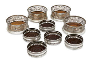 
	
		A set of four German silver and turned wood openwork bottle coasters, Hamburg, Brahmfeld...