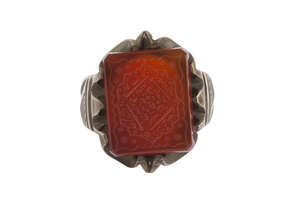An inscribed carnelian ring, Iran, rectangular carnelian inscribed to face with lobed panel containing lines of Persian nasta'liq on a ground on flowers, t