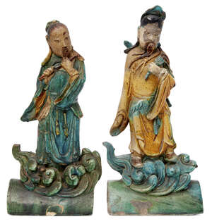 A pair of Chinese pottery figural roof tiles, Ming dynasty, each depicting a Daoist immortal, glazed in tones of brown, green and turquoise, 40cm and 38cm high