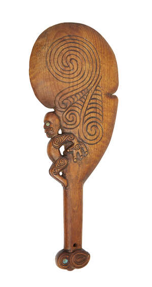 
	
		A Maori wood hand club, early 20th century, with a tiki figure projecting from the side...