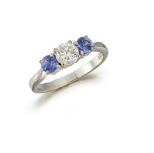 
	
		A platinum, diamond and sapphire three stone ring, the central claw-set circular-cut...