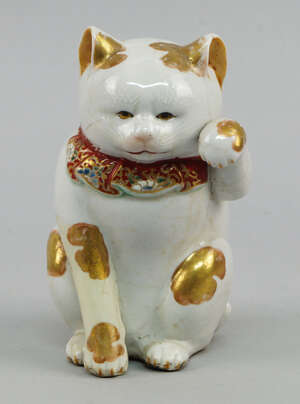 
	
		A Japanese pottery model of a seated cat, late 19th/early 20th century, enriched with...