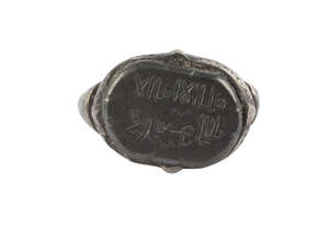 A hematitie inscribed ring, Iran, 11th-13th century, the bezel of oval form with two lines of kufic inscription, the band plain, ring size m approx. 
		 
		P
