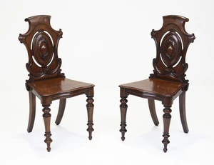 A pair of William IV mahogany hall chairs, second quarter 19th century, with carved backs, on...