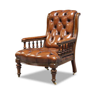 
	
		A late Victorian mahogany button back armchair, upholstered in brown faux leather, with...