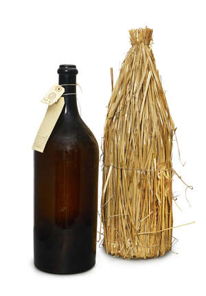 
	
		A French brown glass Jeroboam Champagne bottle, late 19th century, with a straw carriage...