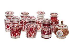 
	
		A Bohemian overlay glass jar and cover, 19th century, decorated with vignettes of a child...