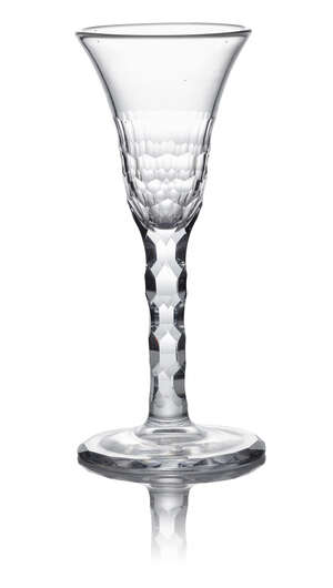 A George III facet stem wine flute, c. 1785, with ogee bowl, with hexagonal cut facets to the lower half and bridge continuing to the hexagonal cut stem, stand