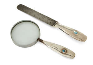 
	
		Liberty & Co (British), a silver page turner and magnifying glass both handles set with...