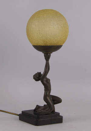 
	
		An Art Deco metal table light, the base in the form of a lady wearing a tightly fitting...