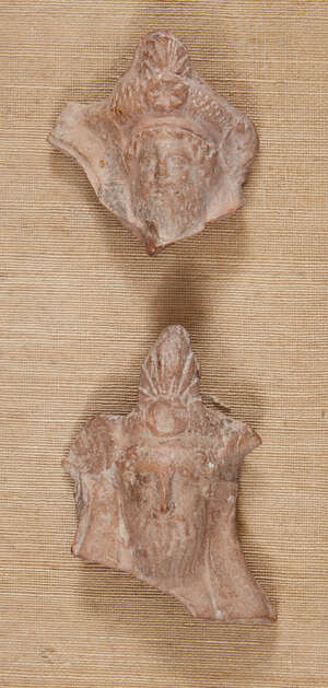 Two Greek terracotta hollow-backed relief fragments, each of a bearded male banqueteer wearing...