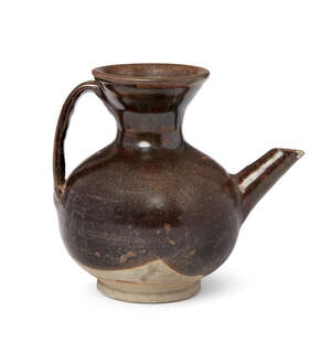 A Chinese grey stoneware ewer, Yuan dynasty, with strap handle and angular spout, the dark brown glaze stopping above the foot, 10.5cm high