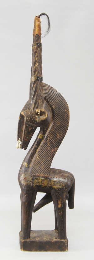 
	
		A tribal antelope sculpture, Bambara, with writhen carved horns, the ears and nose hung...