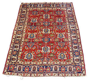 
	
		A Tabriz rug, early/mid 20th century, with rows of blue medallions in claret coloured...