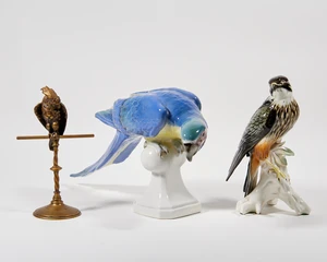 A Karl Ens figure of a peregrine falcon, 20th century, modelled perched atop a branch, 17 x 24cm high; together with a Royal Dux figure of a macaw parrot, in t