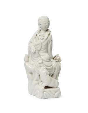 
	
		A Chinese dehua figure group, 18th/19th century, modelled as Guanyin seated, with a...