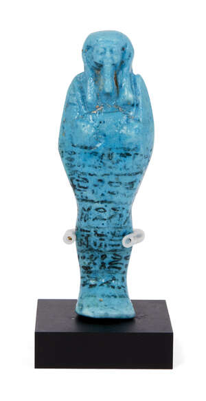 
	
		An Egyptian blue-glazed composition shabti, 26th Dynasty, modelled with arms crossed...