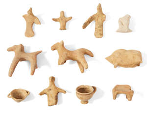 A group of Cypriot buff pottery figures, Cyprus, early to first Millennium B.C., comprising two small handled vessels, a pig, a dog, a chair and several warrio