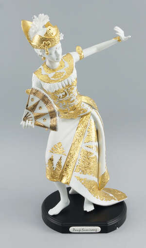A porcelain figure of a Balinese dancing girl by Nuanza Porselen Indonesia, of recent manufacture, modelled holding a fan, in gilded clothing, 45.5cm high, wit