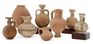 A group of pottery vessels including a Cypro-Mycenaean vessel with squat globular body and loop handle, the buff coloured body decorated with groups of encircl