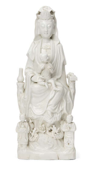 A large Chinese Dehua porcelain figure of Guanyin, 17th/18th century, Guanyin modelled seated on a rockwork throne holding a small boy in her lap wearing a lon