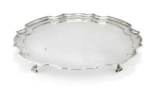 A silver salver with Chippendale-style edge, Sheffield, c.1922, James Dixon & Sons., of circular form, the flat base raised on four scroll feet, 20.7cm dia., a