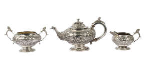 A George IV Scottish silver three piece tea set, Edinburgh, c.1822, George Fenwick, comprising teapot, milk jug and twin handled sugar bowl, deeply cast with f