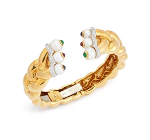 A cultured pearl and gem-set torque bangle, the terminals designed as a row of three cultured...
