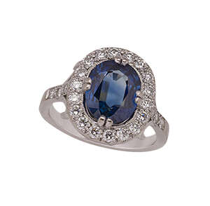 
	
		A French white gold, sapphire and diamond cluster ring, the cushion-shaped sapphire...