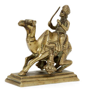 A brass figure of a camel rider, India, circa 1800 or later, on a rectangular tiered base, the...