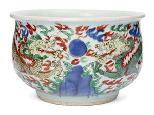 A Chinese porcelain wucai jardiniere, late Ming dynasty, painted to the exterior with with two dragons pursuing the flaming pearl amid clouds and flames, 22cm 