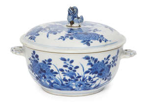 A Chinese porcelain bowl and cover, Kangxi period, painted in underglaze blue with chrysanthemum and peony blossom issuing from rockwork, with two pierced hand