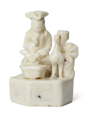 A Chinese Dehua porcelain 'European puppet' whistle, Kangxi period, depicting a European man beside a bird and a vase of flowers, 6.5cm high
		Cf. Bla