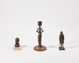 A bronzed copper figural candlestick, 20th century, modelled as a lady draped in cloth holding...