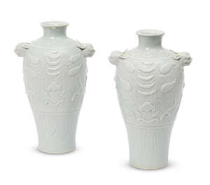 A pair of Chinese porcelain archaistic baluster vases, late Qing dynasty, the shoulder moulded with a band of lotus scrolls and dragons above pair of mythical 