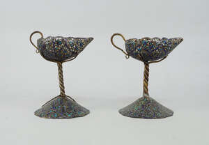 
	
		A pair of copper and enamel candlesticks, late 19th/early 20th century, of Middle Eastern...