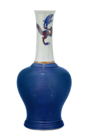 A rare Chinese porcelain bottle vase, Kangxi period, the slender, narrow neck painted in underglaze blue and copper red with a chi-long dragon striding forward