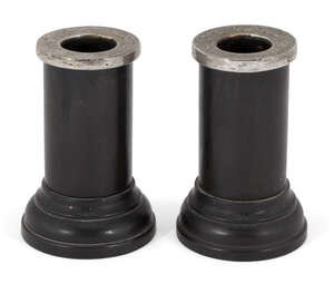 A pair of dwarf ebony candlesticks with silver mounted sconces, London, c.1914, H F Daltrey & Co., the cylindrical candlesticks with stepped circular feet and 