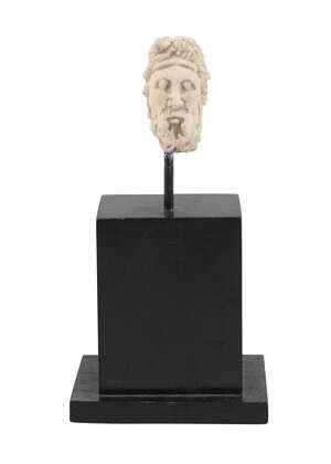 A Roman head of a bearded man. 2nd-3rd century AD, with sculpted curly hair, mounted on a plinth, 3.5cm. high
		 
		Provenance: Private UK collection