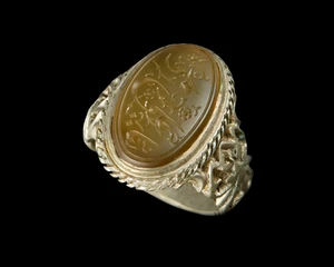 A Qajar ring set with an engraved carnelian seal,Iran, 19th century 
In floral silver mount, the...