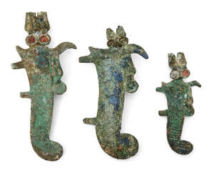Three Egyptian bronze atef crown feathers, Late Period to Ptolemaic, 664-30 B.C., each surmounting a horn and with adjoining rearing uraeus, with tangs on the 