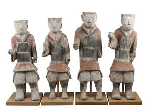 Four large Chinese grey stoneware guardian figures, Han dynasty, each modelled standing, wearing a soldier's cap and breastplate, with painted facial featu