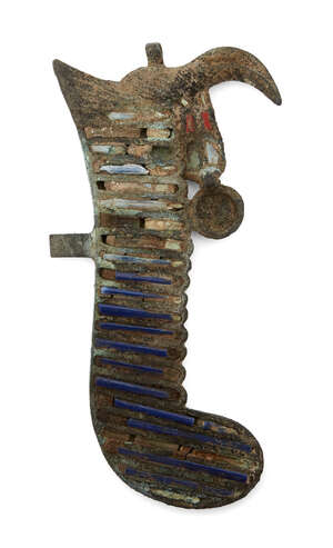 An Egyptian bronze feather from an atef crown surmounting a horn, Late Period to Ptolemaic, 664-30 B.C., the feather surface inlaid with most of the blue glass