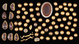 
	
		A group of gold domed elements, an agate and a group of red glass and gold elements,...