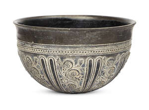 A Greek Bucchero-style bowl, 7th century B.C., with flat base, rounded sides and slightly everted rim, the relief-carved floral decorations extending upwards f