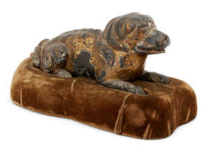 
	
		A Chinese parcel gilt carved wood dog, 17th/18th century, carved in recumbent pose with...