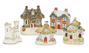 
	
		A Staffordshire pottery money box in the form of a cottage, 19th century, together with...