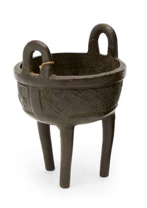 
	
		A Chinese bronze miniature tripod vessel, ding, 17th century, with high loop handles to...